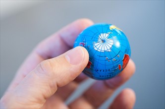 Hand holding globe with Antarctica