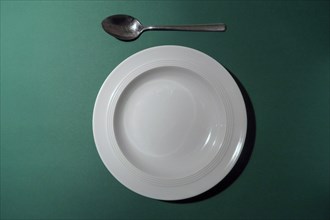 Empty white plate with spoon