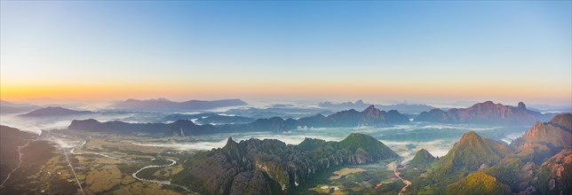 Panorama of karst mountains with mist at sunrise
