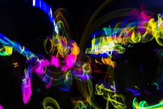 Colorful lights from glow sticks at a dark party using long exposure light effect