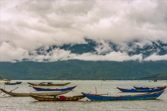 Fishing boats on sea at coast with dramatic stormy clouds in Hue