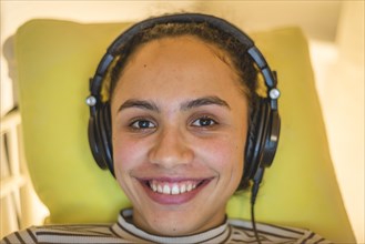 Young woman with headphones smiles