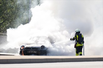 Firefighter extinguishes burning car