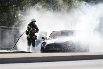 Firefighter extinguishes burning car