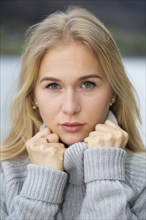 Portrait of a young woman with long blond hair and warm sweater