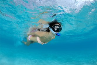 Young woman is snorkeling at the water surface