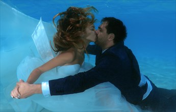 Newlyweds kissing underwater