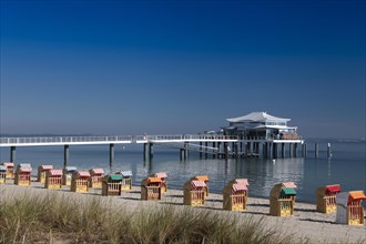 Beach chairs on Timmendorfer beach with Seeschlosschenbrucke bridge and Japanese teahouse