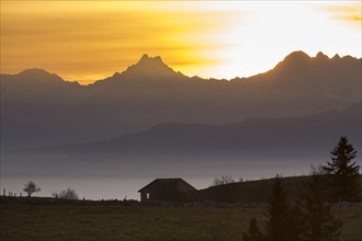 A cabin on the Creux du Van at sunrise overlooking the mountains Schreckhorn