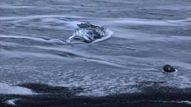 Stranded iceberg beside the lava of Breidarsandur