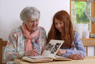Granddaughter and grandmother looking at a photo album
