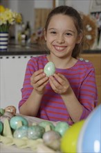 Girl colouring Easter eggs for the Easter basket