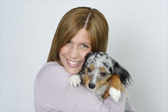 Young woman holding young dog