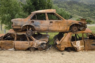 Stack of three rusty car wrecks