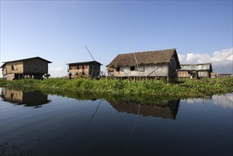 Traditional stilt houses in Inle Lake with reflection in the water