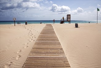 Boardwalk over the sand dunes to the sea with lifesaver station