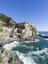 Rocky coast and view to the village of Manarola