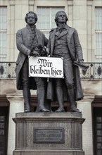 Goethe and Schiller monument with sign Wir bleiben hier or We stay here