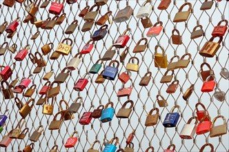 Love locks hanging on metal grid