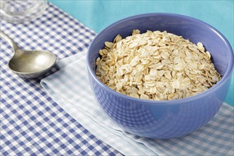 Oats flakes or porridge oats in blue bowl on breakfast table