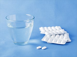 Tablets with blister packaging and glass of water