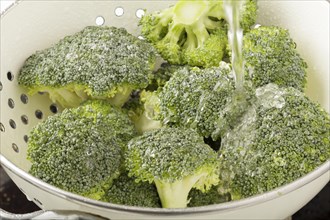 Broccoli being washed in a colander