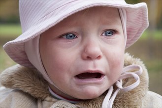 Little girl with pink cap crying