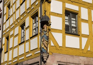 Figure Saint Giles on an old half-timbered house in the Weissgerbergasse