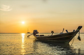 Longtail boat in the sea at sunset