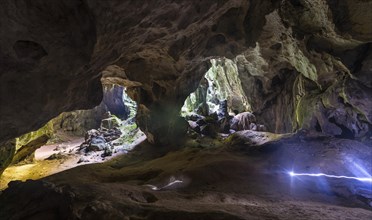 Hikers walking through a large cave