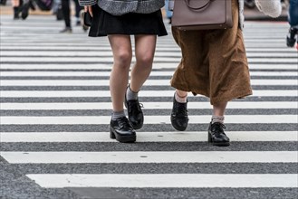 Two pedestrians crossing zebra crossing