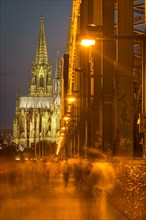 Hohenzollern Bridge at night with pedestrians