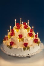 Wedding cake with marzipan roses and lit candles