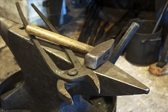 Old blacksmith's anvil with hammer and pincer