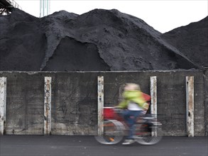 Cyclist riding past coal ash heap