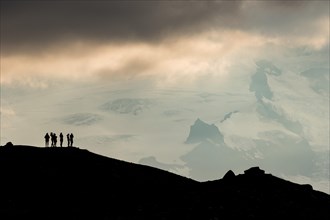 Silhouette of tourists at the ridge with view of Hvannadalshnukur and glacier Oraefajokull