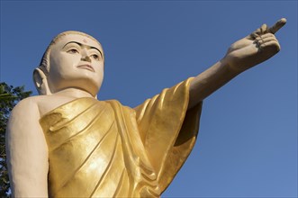 Buddha statue with extended arm and pointing finger