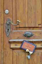 Wooden door with sign saying "Bin im Garten"
