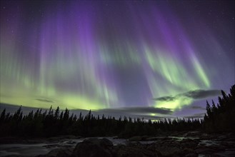 Northern Lights or Aurora Borealis over the river Gamajahka or Kamajakka