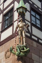 Saint George figure with dragon on a half-timbered house in the medieval town center of Nuremberg