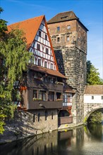 Old half-timbered house and water tower by the river Pegnitz