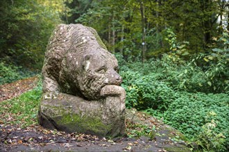 Wooden bear sculpture in front of Barenhohle in autumn near Pirmasens