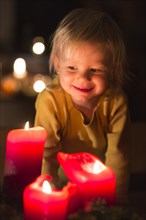 Toddler looking at advent candles at Christmas time