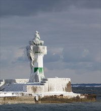 Icy lighthouse in harbour
