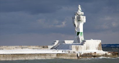 Icy lighthouse in harbour