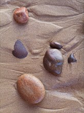 Pebbles in the sand at Legzira beach at the shore of the Atlantic Ocean