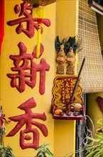 Chinese characters on a column and oblation in the district of Kampung Dua