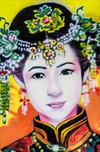 Painted image of a traditionally dressed woman on a house wall