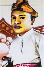 Painted image of a traditionally dressed man on a house wall