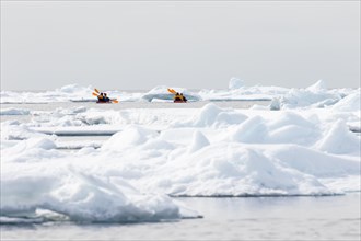 Canoeists amid icebergs on the sea ice edge of North Spitsbergen